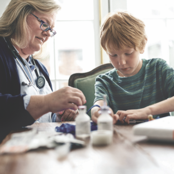 Healthcare Assistant administering medications to a young patient