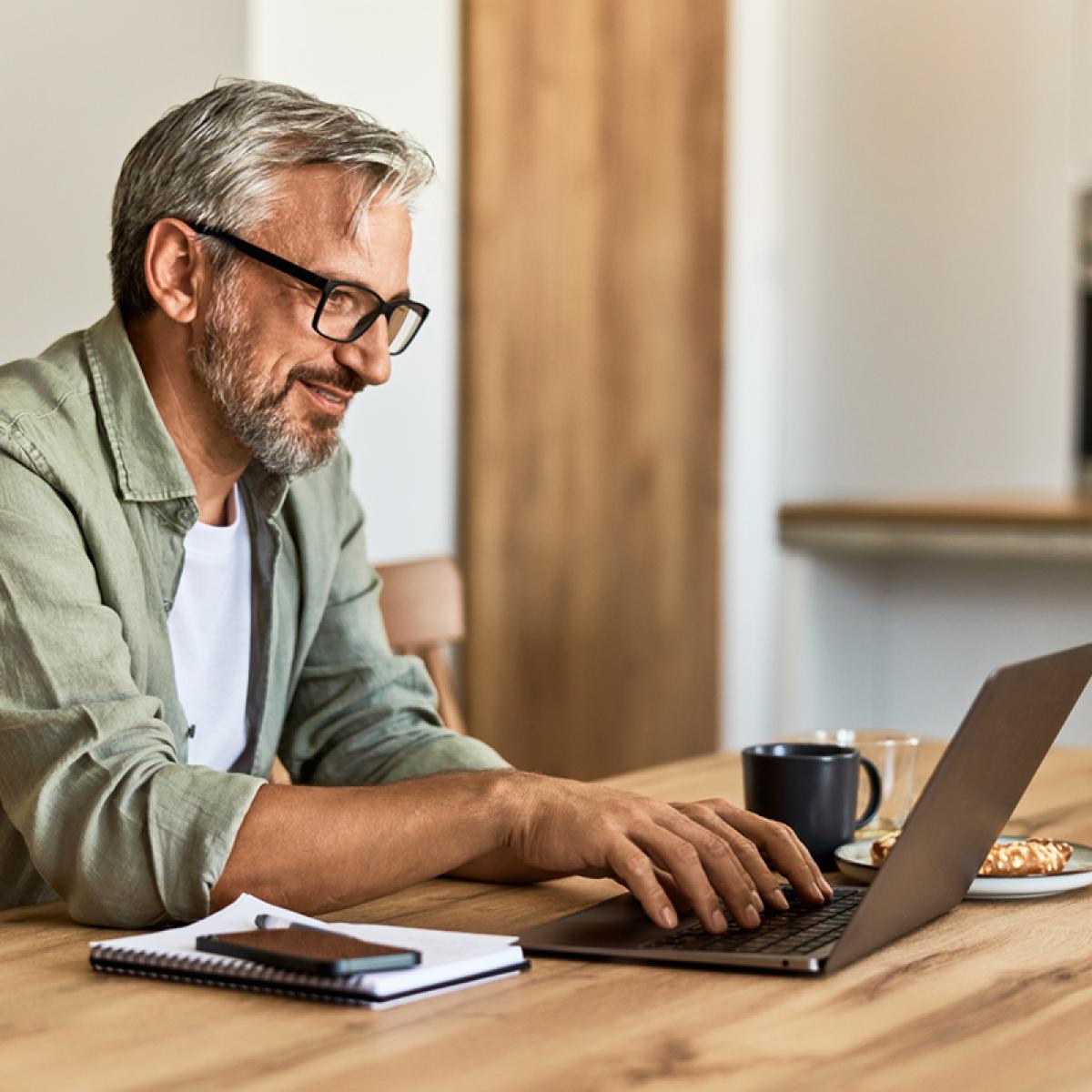 Man looks at laptop on desk